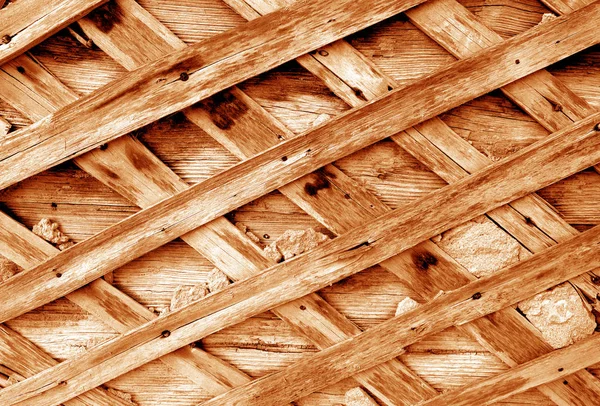 Gammal skadad byggvägg med träelement i orange ton. — Stockfoto