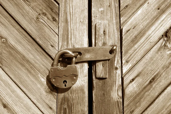 Grungy houten deur met slot in bruine toon. — Stockfoto