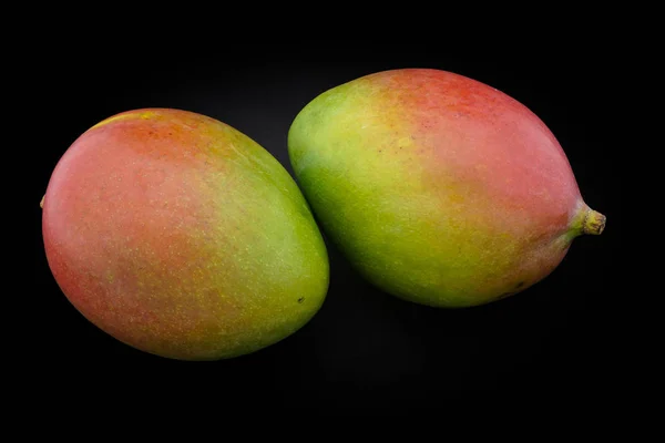 Mango zelené a červené barvy na černém pozadí closeup — Stock fotografie