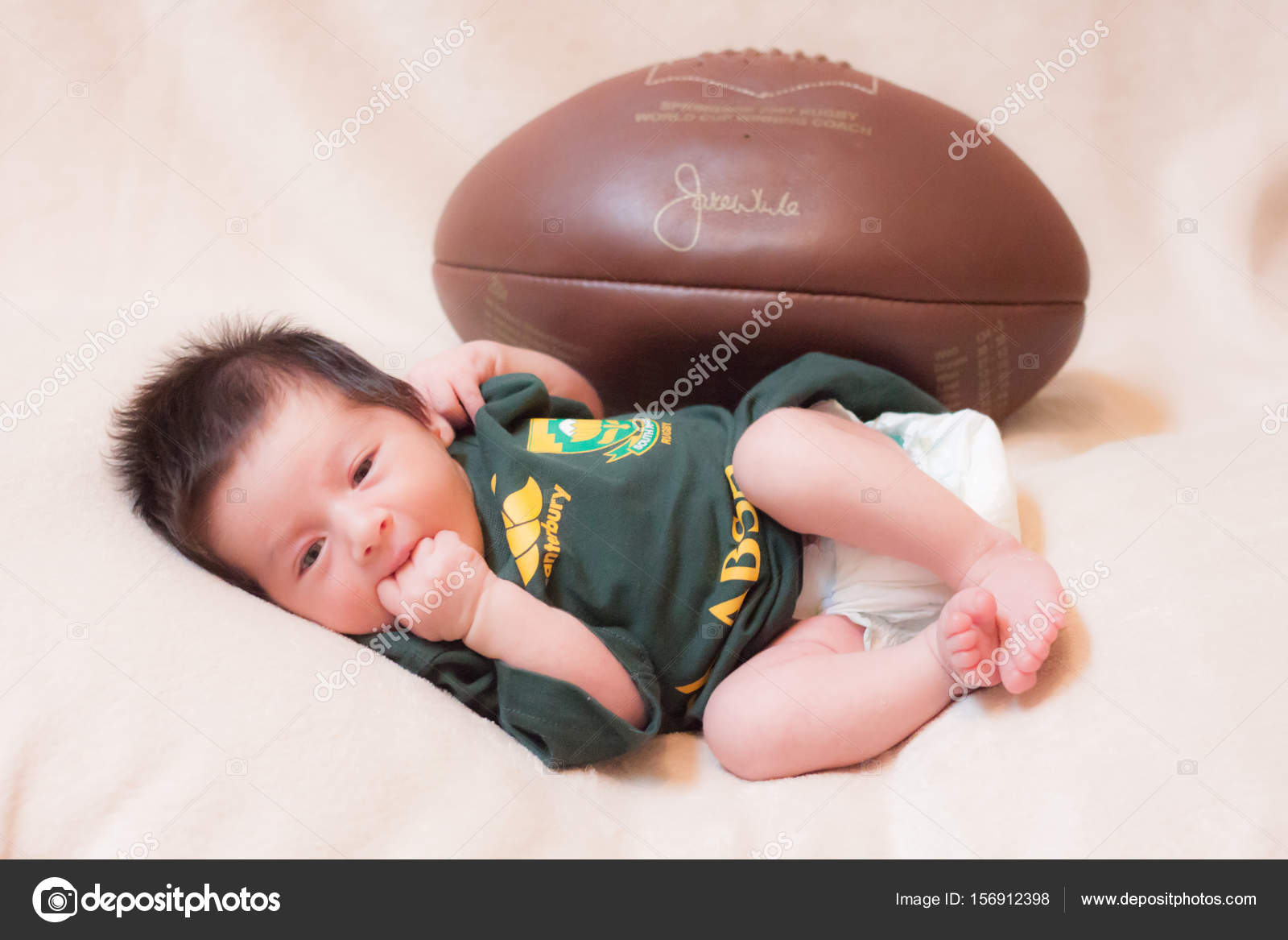 Baby with a rugby uniform and ball Stock Photo by agevole 156912398