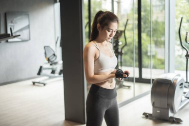 Güzel Asyalı kadın spor salonunda egzersiz yapıyor. 