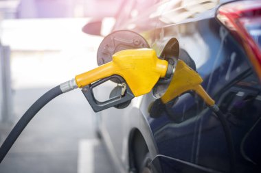 Benzin istasyonunda arabanın yakıtını dolduruyorlar.