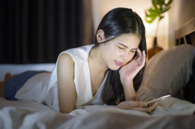 Kadın gece akıllı telefon kullanırken göz ağrısı çekiyor.