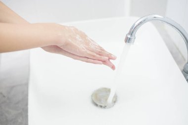 Bir kadın ellerini yıkıyor. 