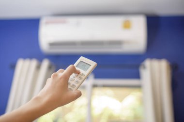 Kadın evdeki klimayı açıyor.