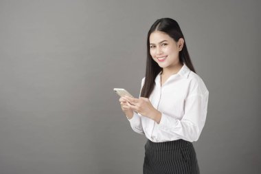 Güzel bir kadın stüdyoda cep telefonu kullanıyor. 