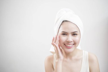 Bir kadın yüzüne krem sürüyor. 