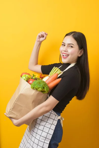 Mulher Bonita Está Segurando Legumes Saco Supermercado Estúdio Fundo Amarelo — Fotografia de Stock