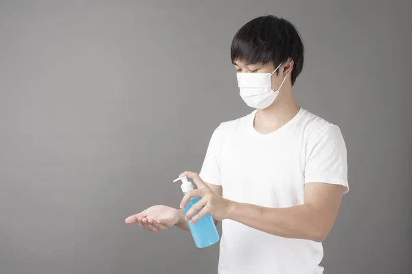 Ένας Όμορφος Άντρας Χειρουργική Μάσκα Χρησιμοποιεί Απολυμαντικό Χεριών Αλκοόλ — Φωτογραφία Αρχείου