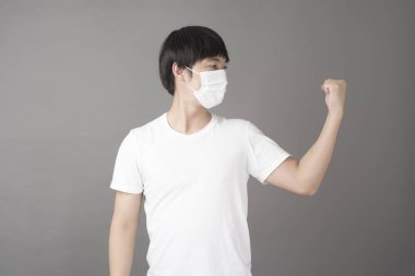 Yakışıklı bir adam stüdyoda cerrahi maske takıyor. 