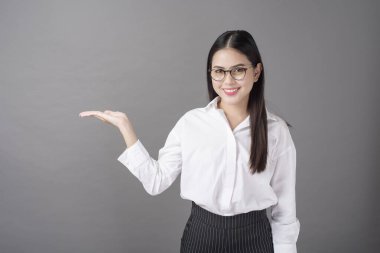 Güzel bir kadın stüdyoda bir şeyler gösteriyor. 