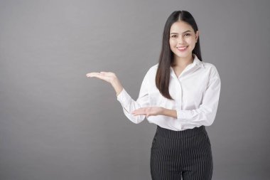 Güzel bir kadın stüdyoda bir şeyler gösteriyor. 