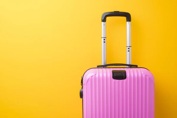 Pink baggage on yellow background, travel concept