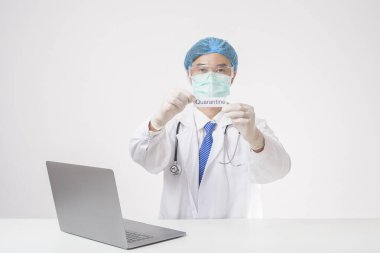 Doktor beyaz arka planda quanrantine kartı tutuyor. 