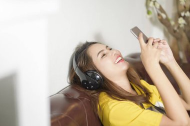Güzel kadın evde müzik dinliyor. 