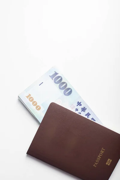 Passport and 1000 New Taiwan Dollar bill on white background