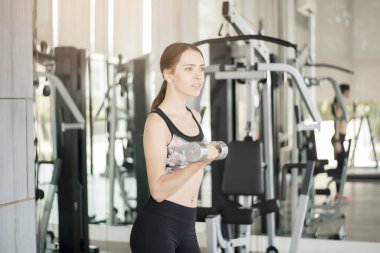 Güzel genç bayan spor salonunda spor yapıyor, sağlıklı bir yaşam tarzı var. 