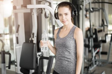 Güzel genç bayan spor salonunda su içiyor, sağlıklı bir yaşam tarzı. 