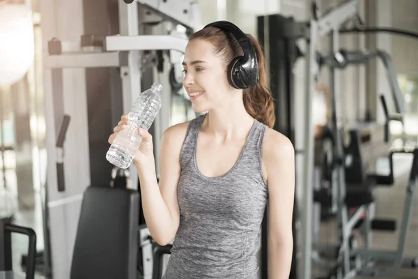 Pretty young sport woman is drinking water  in gym, Healthy lifestyle