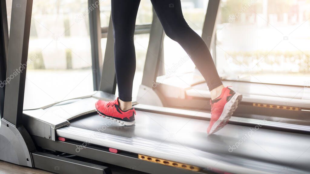 Close up of  woman's muscular legs feet running on treadmill workout at fitness gym, Healthy lifestyle 