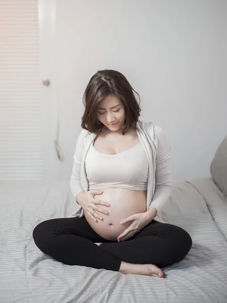 Hermosa Asiático Embarazada Mujer Sentarse Cama Tocando Vientre —  Fotos de Stock