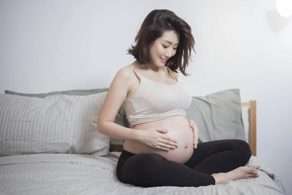 Hermosa Asiático Embarazada Mujer Sentarse Cama Tocando Vientre — Foto de Stock