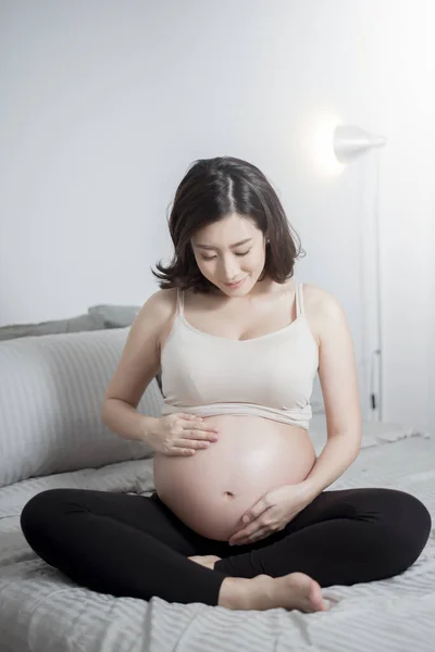 Bela Ásia Grávida Mulher Sentar Cama Tocar Ela Barriga — Fotografia de Stock