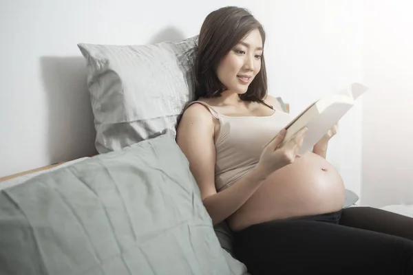 Schöne Asiatische Schwangere Frau Liegt Auf Ihrem Bett Und Liest — Stockfoto