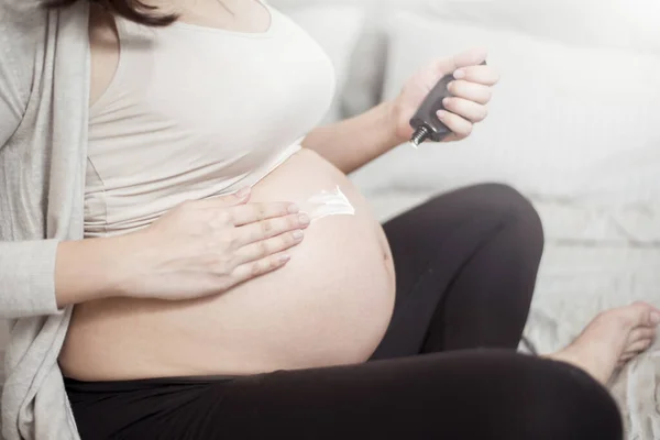孕妇在腹部涂药膏的近视 — 图库照片