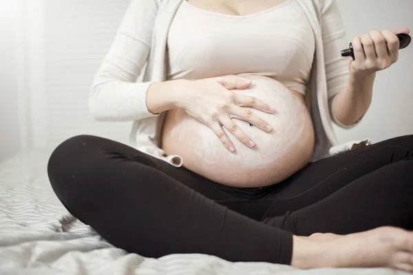 孕妇在腹部涂药膏的近视 — 图库照片