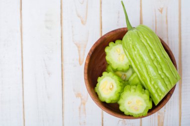 Beyaz ahşap masada acı kavun 