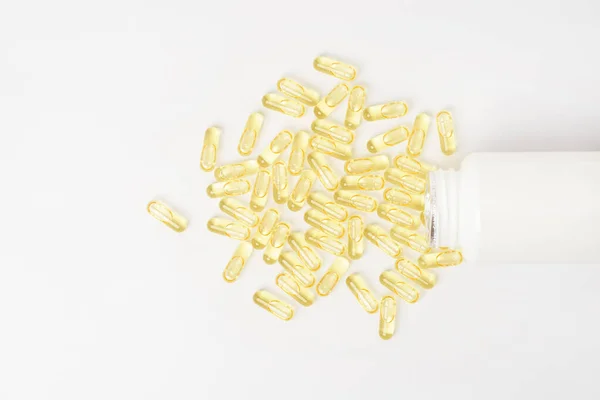 Heaps of yellow vitamins pills on white background