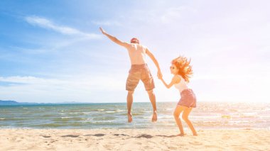 Çift kumsalda zıplıyor.