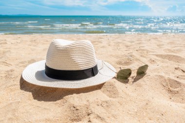 Plajda beyaz şapka ve güneş gözlüğü, yaz konsepti. 