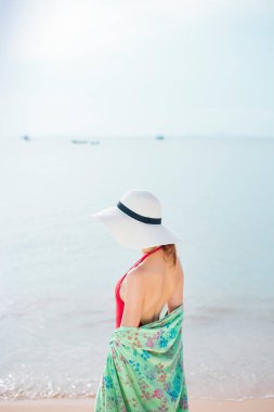 Kumsalda kırmızı mayolu güzel bir kadın. 