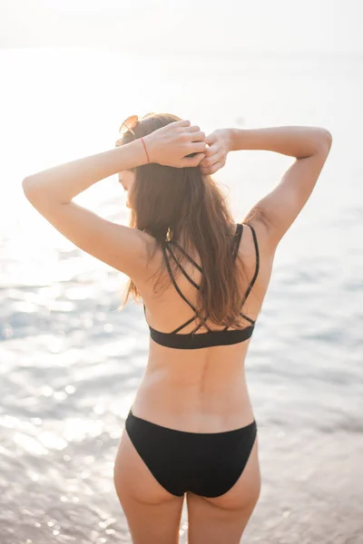 穿着黑色比基尼的漂亮女人正在海滩上放松 夏天的概念 — 图库照片