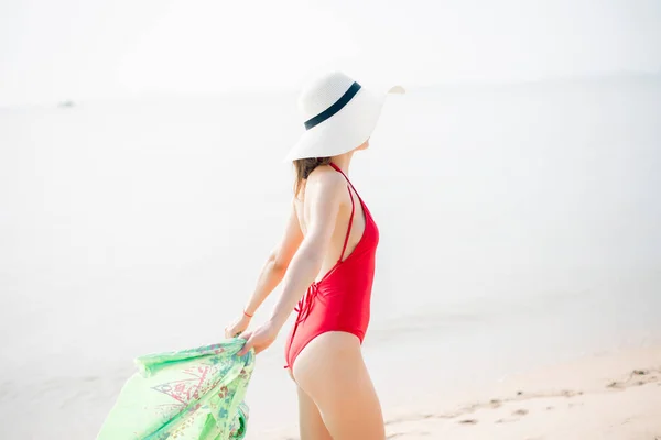 赤い水着の美しい女性がビーチでリラックスしている 夏のコンセプト — ストック写真