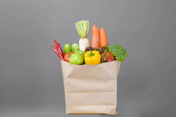 vegetables in grocery bag on studio grey background