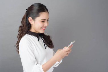 Güzel İş kadını portresi stüdyoda cep telefonu kullanıyor. 