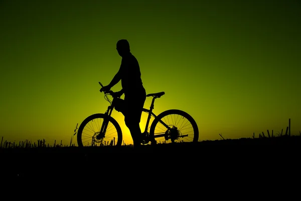Zachód słońca i sylwetka rowerzystów podświetlenia — Zdjęcie stockowe