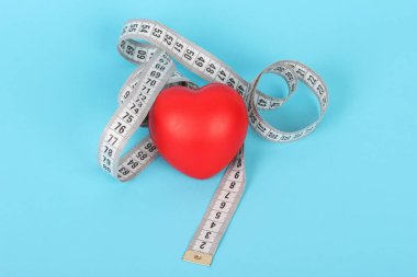 On blue background and red heart tape measure.Fitness, Health, Medical, diet concept
