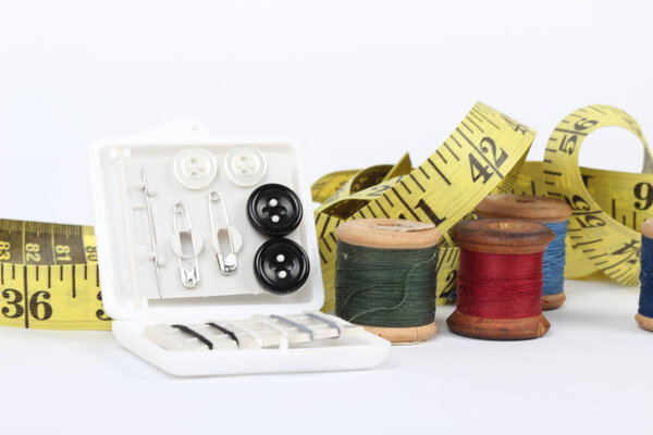 Шитье предметов и ленты меры изолированы на белом фоне
