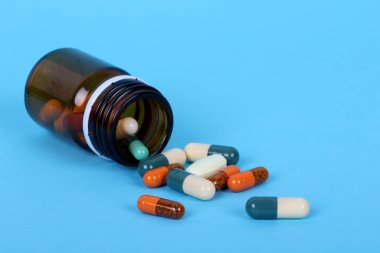 Mavi arka planda izole tıbbi şişeler, uyuşturucu ve