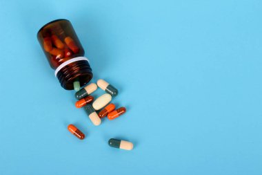 Mavi arka planda izole tıbbi şişeler, uyuşturucu ve