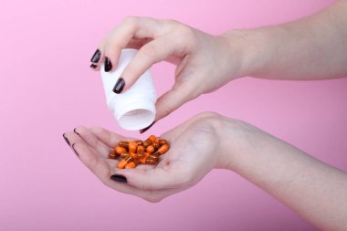 Pembe arka plandaki bir kadının eline reçeteli ilaçlar döküldü.