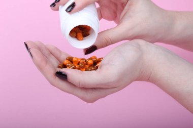 Pembe arka plandaki bir kadının eline reçeteli ilaçlar döküldü.