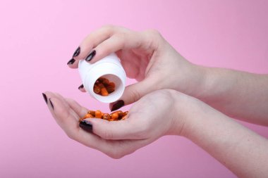 Pembe arka plandaki bir kadının eline reçeteli ilaçlar döküldü.