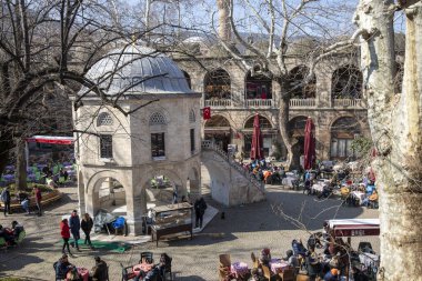 Bursa / Türkiye - 02 / 23 / 2020: Koza Han İpek Pazarı 'ndaki çay bahçeleri, ipek dükkanları ve tarihi cami. Koza Han tarihi ve Osmanlı İmparatorluğu 'ndan çok ünlü bir yerdir. Giriş kapısı Han..