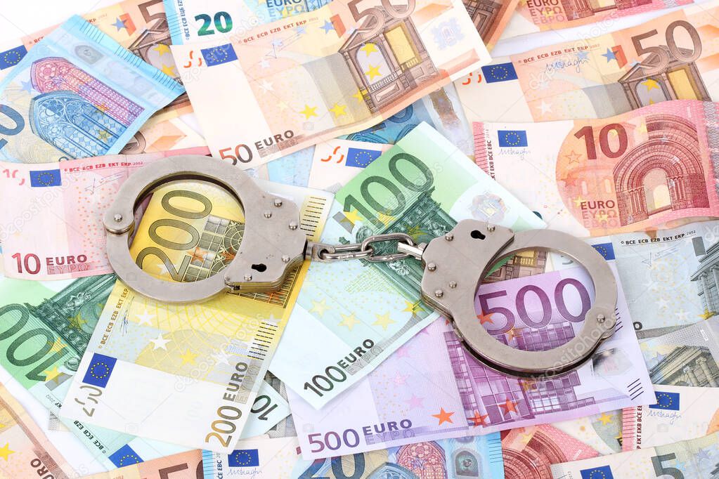 silver handcuffs on many large euro notes
