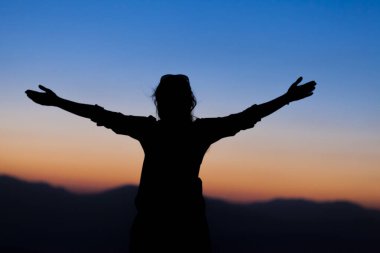 Gün batımında kollarını kaldırdı, yüksek enerjili kadın.